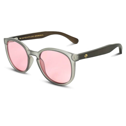 anteojos redondos de plástico reciclado y varillas de madera natural sustentable con lentes de color rosado. Polarizadas y forma redonda. La gafa es color transparente #color_rosado