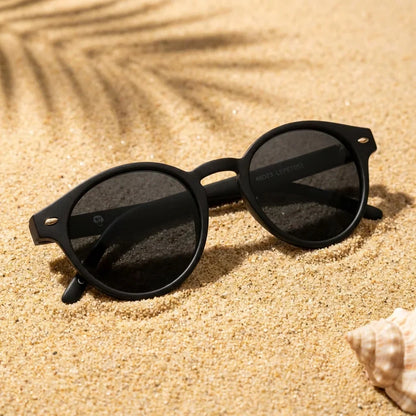 Lentes sol Joplin RPET polarizados UV400 sobre arena dorada costa textura natural Bonoboss #color_negro