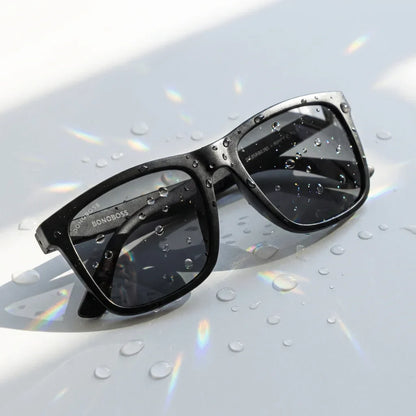 Lentes sol Rapanui RPET polarizados UV400 sobre superficie con agua y luz natural Bonoboss #color_dark