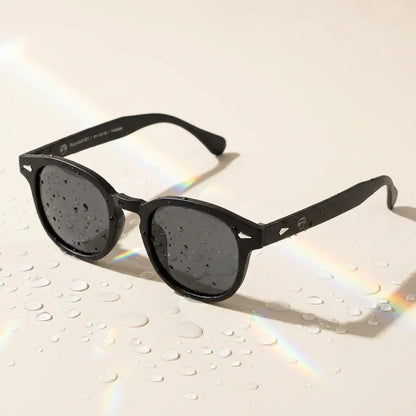 Lentes sol Waimea RPET polarizados UV400 sobre superficie con agua y luz natural Bonoboss #color_negro