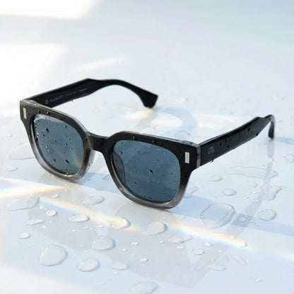 Lentes sol Osorno RPET polarizados UV400 sobre superficie con agua y luz natural Bonoboss #color_degrade-azul