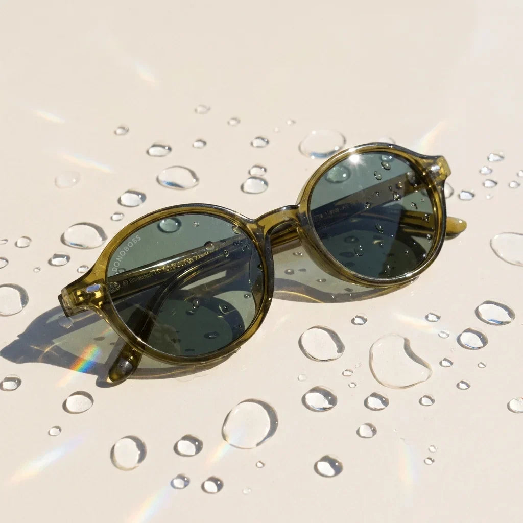 Lentes sol Capri polarizados UV400 sobre superficie con agua y luz natural Bonoboss #color_olive-light