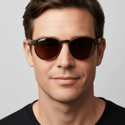 vista frontal de un modelo hombre de cara ovalada usando unos anteojos gafas de sol polarizadas de forma redonda y con puente para narices anchas hechas de plastico reciclado sustentable ecologico personalizada y patas de madera de #color_carey