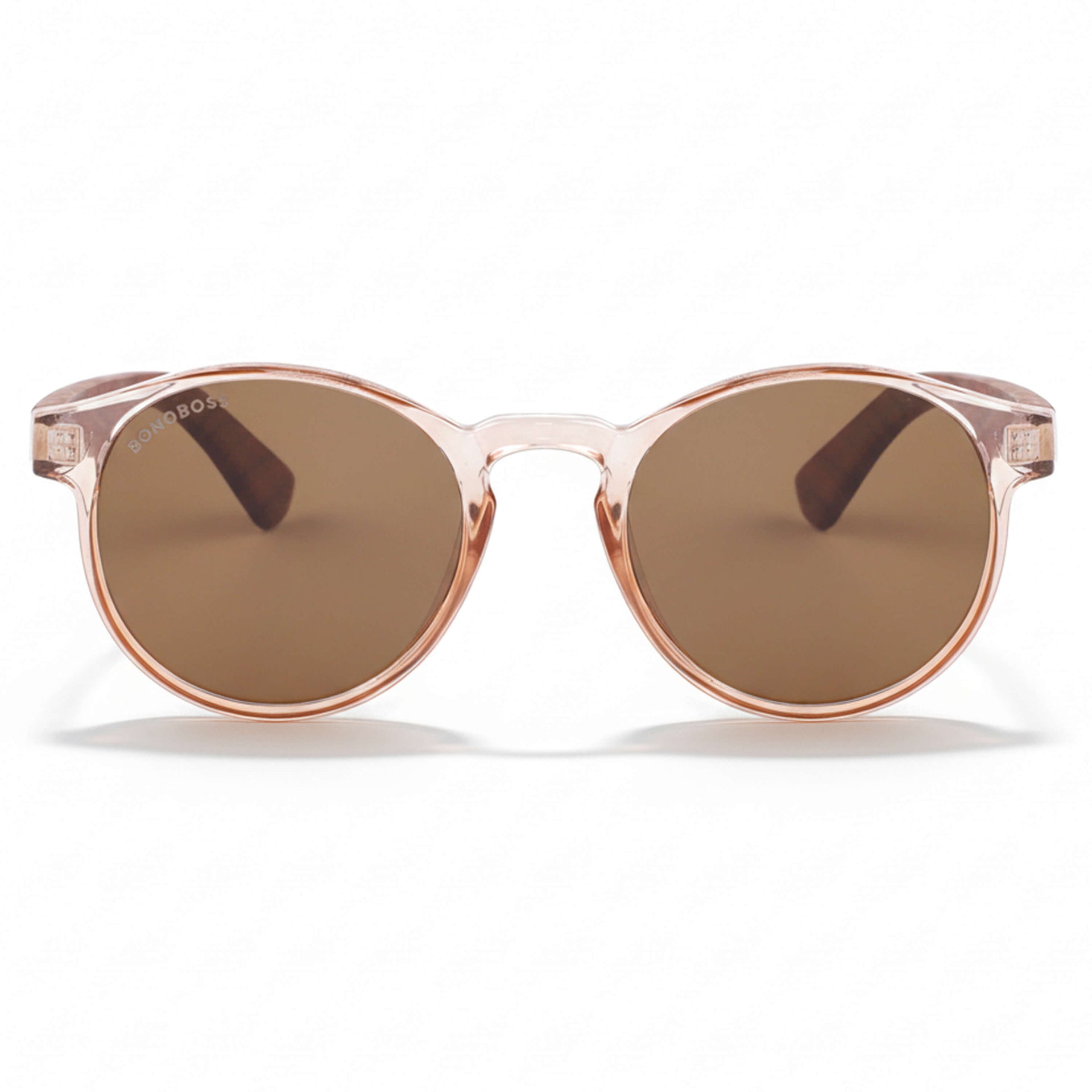 la vista frontal de unos anteojos anteojos gafas de sol polarizadas de forma redonda y con puente para narices anchas hechas de plastico reciclado sustentable ecologico personalizada y patas de madera de #color_rosa