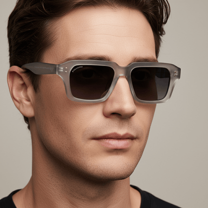 la vista lateral de un modelo hombre de forma de cara redonda usando unos anteojos gafas de sol polarizadas de plastico reciclado sustentable personalizada para regalo corporativo de #color_gray
