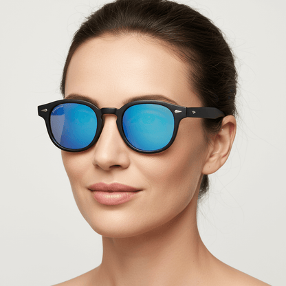 la vista lateral de una mujer usando unos anteojos de sol espejados polarizados de forma redondeada hechos con plastico reciclado personalizado para regalo corporativo de #color_dark-sky