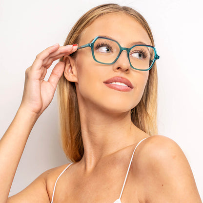 una mujer de pelo rubio y de cara ovalada utilizando unos armazones o anteojos opticos Bonoboss de color calipso o verdes sonriendo hacia la parte superior derecha del cuadro#color_calipso