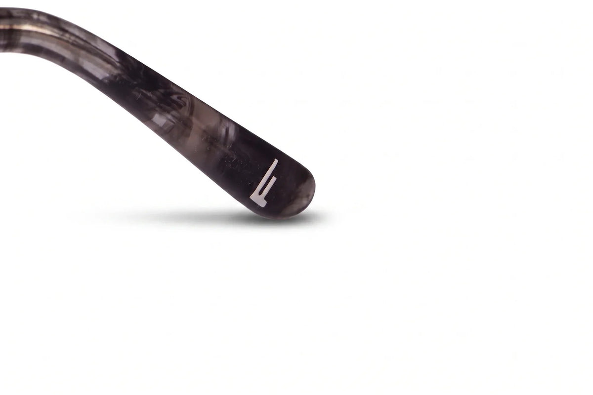 Anteojos de sol Fiore 22115 Gris con cristal gradiente gris: detalle del logo grabado en la patilla #color_gradiente-gris