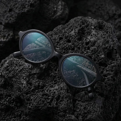Lentes opticos Guapi Island Negro sobre arena volcanica superficie texturizada antirreflex receta optica bio-acetato Bonoboss #editorial_volcanica #color_negro