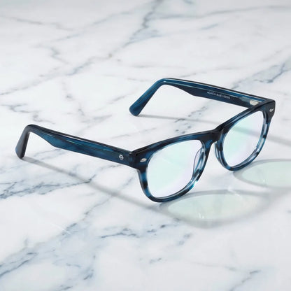 Lentes ópticos Acacia Azul sobre mármol blanco elegante armazón premium Bonoboss #editorial_armazon #color_azul