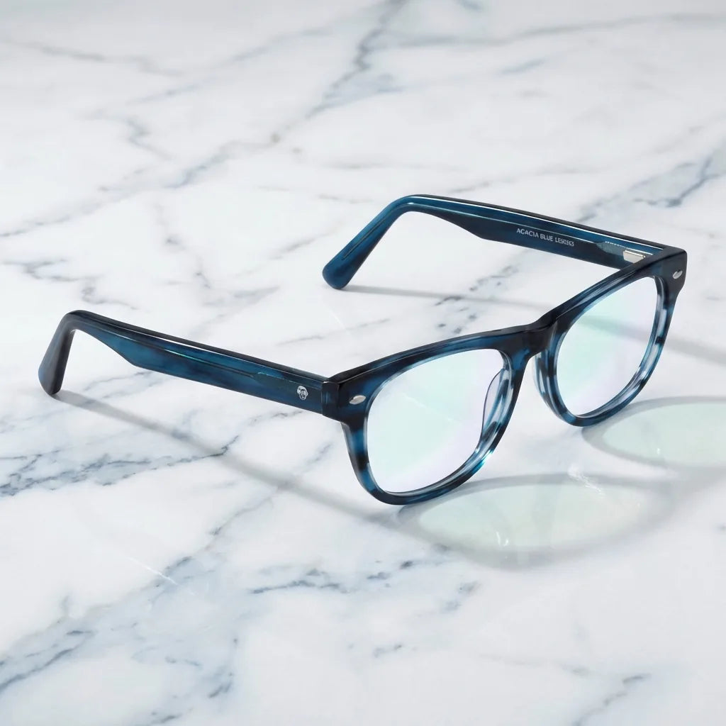 Lentes ópticos Acacia Azul sobre mármol blanco elegante armazón premium Bonoboss #editorial_armazon #color_azul
