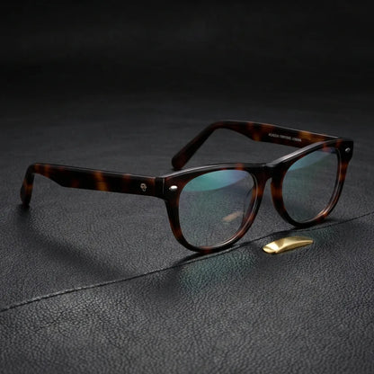 Lentes ópticos Acacia Carey sobre cuero negro con detalle brass dorado calidad premium receta Bonoboss #editorial_banner_confianza #color_carey