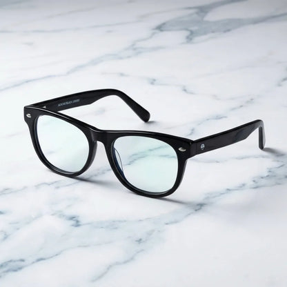 Lentes ópticos Acacia Negro sobre mármol blanco elegante armazón premium Bonoboss #editorial_armazon #color_negro