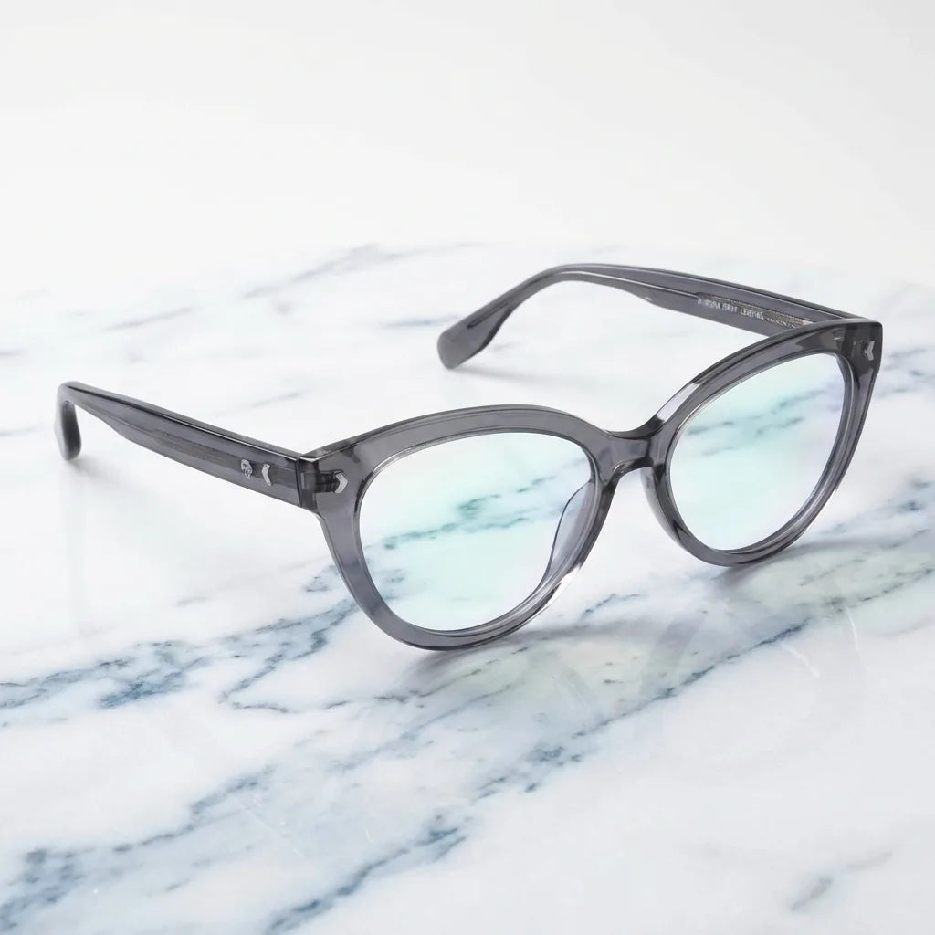 Lentes ópticos Aurora Gris sobre mármol blanco elegante armazón premium Bonoboss #editorial_armazon #color_gris