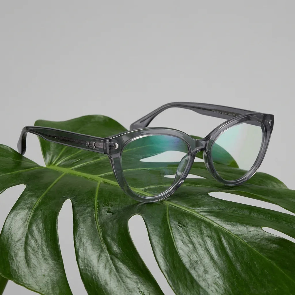 Lentes ópticos Aurora Gris entre hojas botánicas naturales diseño sustentable Bonoboss #editorial_sustentabilidad #color_gris