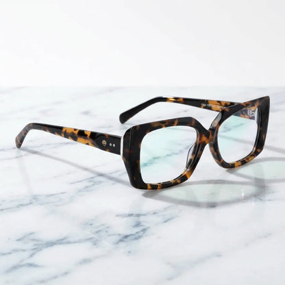 Lentes ópticos Domi Carey sobre mármol blanco elegante armazón premium Bonoboss #editorial_armazon #color_carey