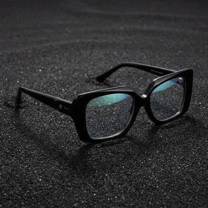 Lentes ópticos Domi Negro sobre arena volcánica texturizada diseño sustentable Bonoboss #editorial_sustentabilidad #color_negro