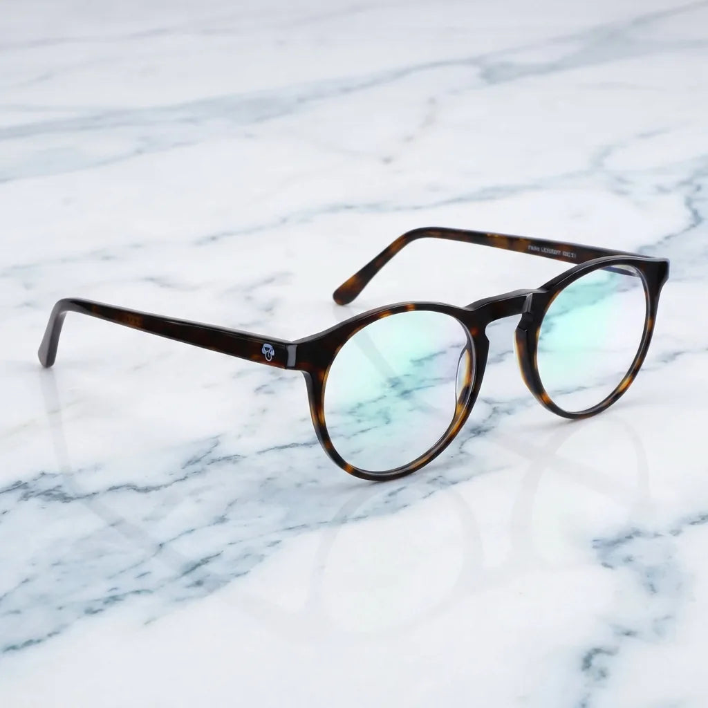 Lentes ópticos Fran 1 Carey sobre mármol blanco elegante armazón premium Bonoboss #editorial_armazon #color_carey