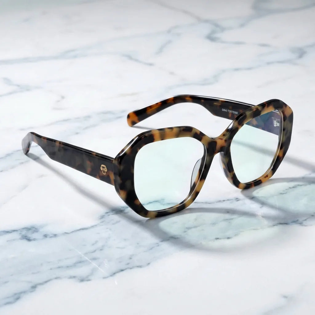 Lentes ópticos Gaia Carey sobre mármol blanco elegante armazón premium Bonoboss #editorial_armazon #color_carey