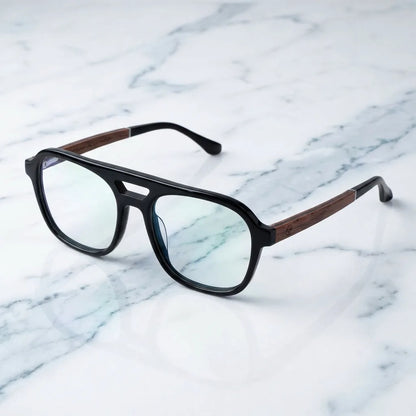 Lentes ópticos Orson Negro sobre mármol blanco elegante armazón premium Bonoboss #editorial_armazon #color_negro