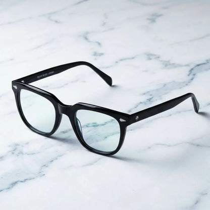 Lentes ópticos Selkie Negro sobre mármol blanco elegante armazón premium Bonoboss #editorial_armazon #color_negro