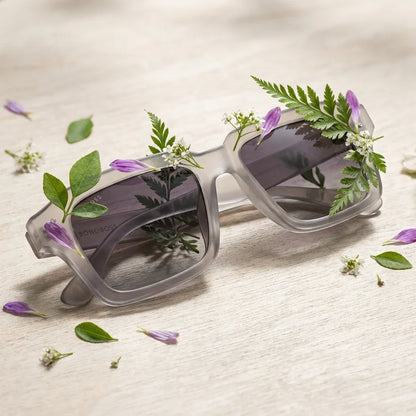 Lentes sol Verona polarizados RPET reciclado del oceano gray entre follaje botanico detalle lente natural Bonoboss #editorial_grid2 #color_gray